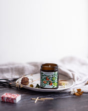 Load image into Gallery viewer, A big size candle with a painted label of oranges, bergamot and blossoms sits on a wooden table